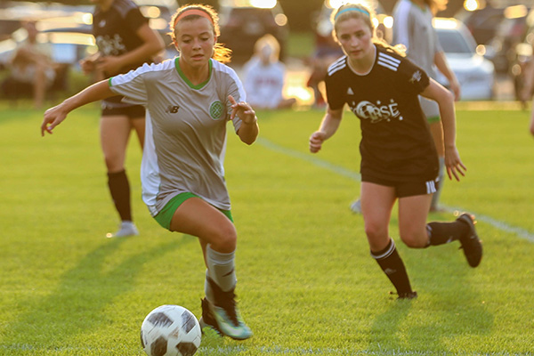 Two soccer players vying for the ball