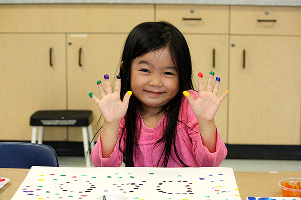 Young girl with paint on her fingers as she finger paints