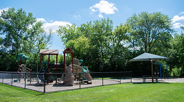 A play structure with a covered picnic table at Willowwood park