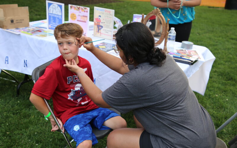 Kid getting face painted at Canine Carnival